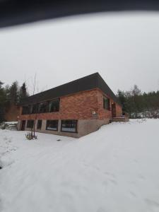 a large brick building with snow in front of it at Villa Talo in Rovaniemi +10 photos