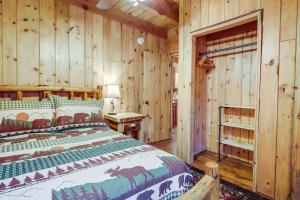 a bedroom with a bed in a log cabin at Rustic Retreat Walk to Great Sacandaga Lake! in Broadalbin