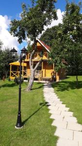 una casa con un árbol y una luz de la calle en el césped en Namelis sodyboje Lazduona, 
