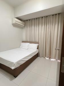 a small bedroom with a bed and a window at Admiral Baysuites 1 BR Unit in Manila