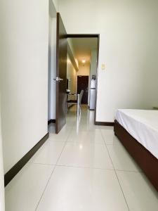 a hotel room with a bed and a dining room at Admiral Baysuites 1 BR Unit in Manila