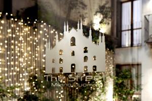 a white building with lights in front of a building at The Street Milano Duomo | a Design Boutique Hotel in Milan