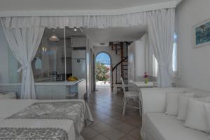 メガロホリにあるCaldera View Private Villaのベッドルーム1室(ベッド1台付)、キッチン、テーブルが備わります。