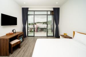 a hotel room with a bed and a television at UYÊN GIA HOTEL-PHÚ QUỐC in Phu Quoc