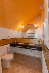 a bathroom with two sinks and a toilet at Caldera View Private Villa in Megalochori