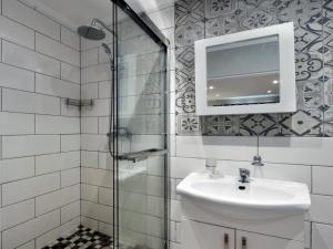 een badkamer met een wastafel en een glazen douche bij La Rochelle Cottage in Franschhoek +15 foto's