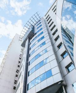 un edificio alto con ventanas de cristal. en Plaza Real Suites Hotel en Rosario