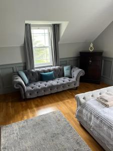 a living room with a couch and a window at clover cottage in Kinsale