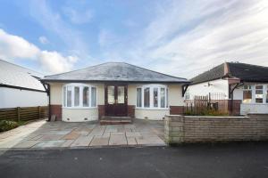 a small white house with a patio at Pass the Keys Cosy Bungalow in Sheffield in Sheffield