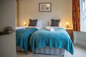 a bedroom with two twin beds with blue blankets at Pass the Keys Cosy Bungalow in Sheffield in Sheffield