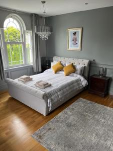 1 dormitorio con 1 cama grande con almohadas amarillas en clover cottage en Kinsale