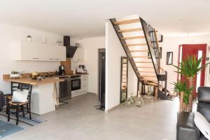 eine Küche und ein Wohnzimmer mit einer Treppe in der Unterkunft Maison de vacances chaleureuse à 600mdu Bassin in Andernos-les-Bains