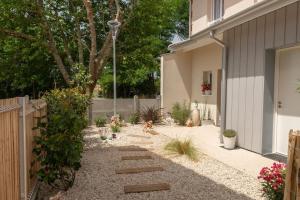 einen Garten mit einem Weg, der zu einem Haus führt in der Unterkunft Maison de vacances chaleureuse à 600mdu Bassin in Andernos-les-Bains