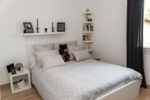 ein Schlafzimmer mit einem Bett mit einem Teddybär drauf in der Unterkunft Maison de vacances chaleureuse à 600mdu Bassin in Andernos-les-Bains