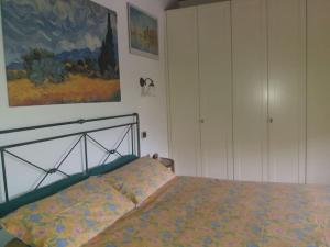 ein Schlafzimmer mit einem Bett und einem Wandgemälde in der Unterkunft Casa Colori (C.I.R. 014051) in Poggiridenti