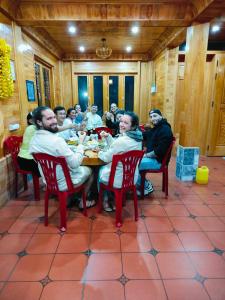 eine Gruppe von Menschen, die in einem Restaurant an einem Tisch sitzen in der Unterkunft Hmong Wooden Home in Sa Pa