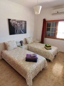 ein Schlafzimmer mit 2 Betten und einem Bild eines Elefanten in der Unterkunft Villa Juanita, Puerto del Carmen, Lanzarote in Tías