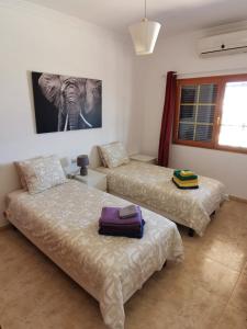 a bedroom with two beds and a picture of an elephant at Villa Juanita, Puerto del Carmen, Lanzarote in Tías