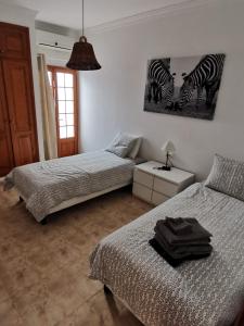 two beds in a bedroom with two zebras on the wall at Villa Juanita, Puerto del Carmen, Lanzarote in Tías