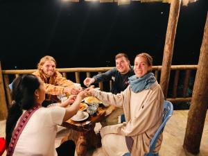 サパにあるHmong Wooden Homeの食卓に座って食べる人々