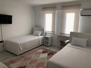 a room with two beds and a flat screen tv at edr ulus 22otel in Edirne
