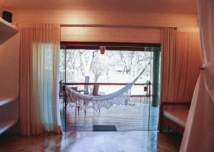 a hammock in a room with a view of a porch at Baguá Bangalôs in Alto Paraíso de Goiás