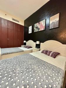a bedroom with two beds and a black wall at Dubai Backpackers in Dubai