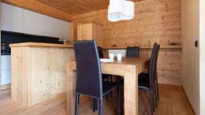 uma sala de jantar com uma mesa de madeira e cadeiras em Sertorelli 27 em Bormio