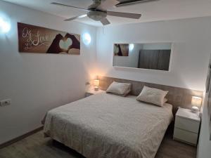 1 dormitorio con 1 cama y ventilador de techo en Bungalow Primavera, en Puerto del Carmen