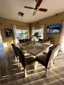 - une table à manger avec des chaises et un ventilateur de plafond dans l'établissement Casa Cabra Corral, à Coronel Moldes