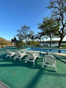 - un groupe de chaises blanches installées à côté de la piscine dans l'établissement Casa Cabra Corral, à Coronel Moldes