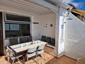 a dining room with a table and chairs on a patio at Bungalow Primavera in Puerto del Carmen