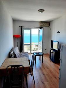 a living room with a table and a view of the ocean at Apartments Elenora in Brist