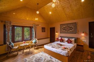 a bedroom with a large bed and a wooden ceiling at Zostel Pahalgam in Pahalgām