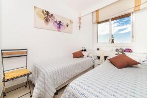 2 Betten in einem Zimmer mit weißen Wänden und Fenstern in der Unterkunft EUREKA Sea Views & Comfort in Cala Millor