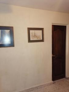two pictures on a wall next to a door at Casa Tajín in Monterrey