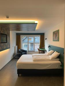Un dormitorio con una cama grande y una ventana en RAVeL Hotel Cyrano en Waimes