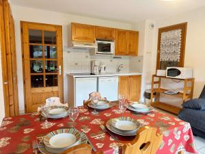 a kitchen with a table with plates and wine glasses at Appartement Samoëns, 3 pièces, 6 personnes - FR-1-624-30 in Samoëns