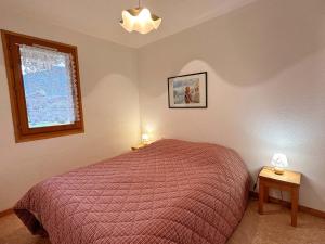 a bedroom with a red bed and a window at Appartement Samoëns, 3 pièces, 6 personnes - FR-1-624-30 in Samoëns