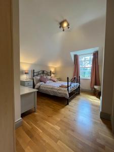 a bedroom with a bed and a desk and a window at clover cottage in Kinsale