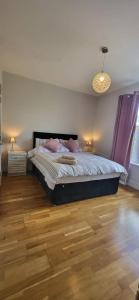 a bedroom with a bed and a wooden floor at clover cottage in Kinsale