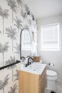 a bathroom with a sink and palm trees wallpaper at Beach Block-1min Walk-Luxury-The Reef Upstairs in Ocean City