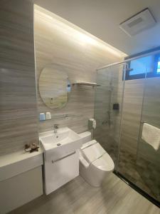 a bathroom with a toilet and a sink and a shower at Ramble Travel Homestay in Guanshan