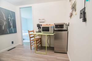 uma cozinha com uma mesa com micro-ondas e um frigorífico em The Flat a Wanderlust Abodes property em Central Lake