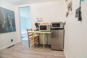 a kitchen with a table with microwaves and a refrigerator at The Flat a Wanderlust Abodes property in Central Lake +16 photos