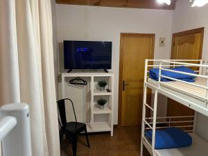 a room with two bunk beds and a television at Alojamiento Rural La Mejora in Conil de la Frontera