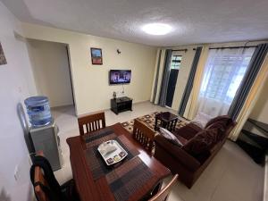 a living room with a couch and a table at Kef Apartments in Nanyuki