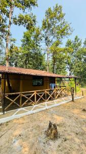 ein Gebäude mit einem Dach auf einem Feld mit Bäumen in der Unterkunft Athulyam Kanha, kanha national park, mukki gate in Khāpa
