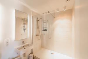 biała łazienka z prysznicem i umywalką w obiekcie Befour w mieście Aalst
