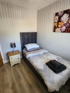 a small bedroom with a bed and a night stand at Southernwood - Wantage Road Apt 2 in Didcot